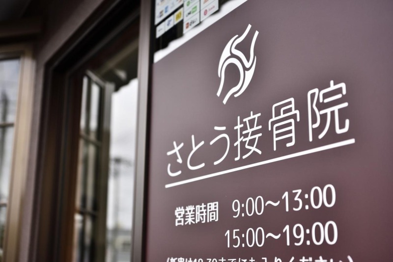 さとう接骨院の入口サイン。営業時間は9:00–13:00/15:00–19:00
