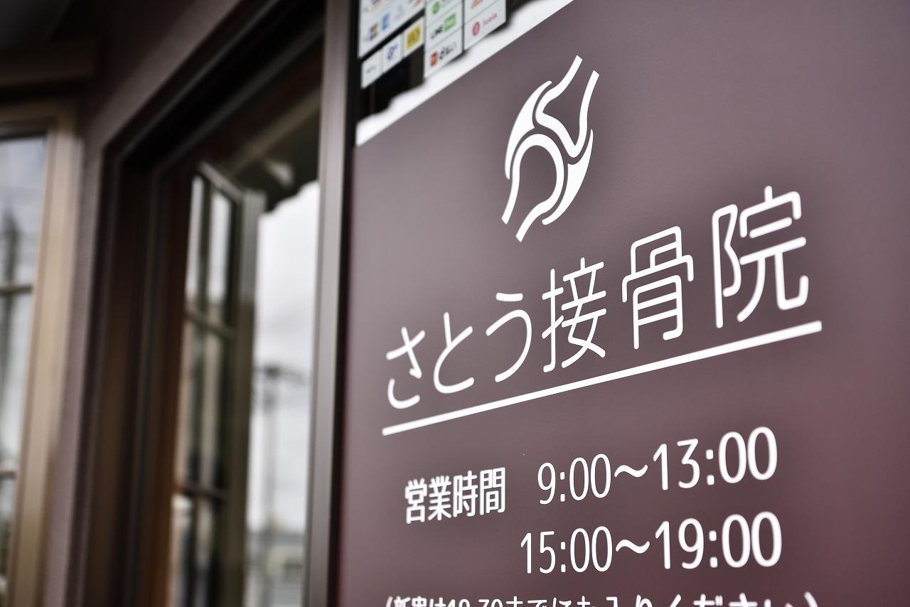 さとう接骨院の入口サイン。営業時間は9:00–13:00／15:00–19:00